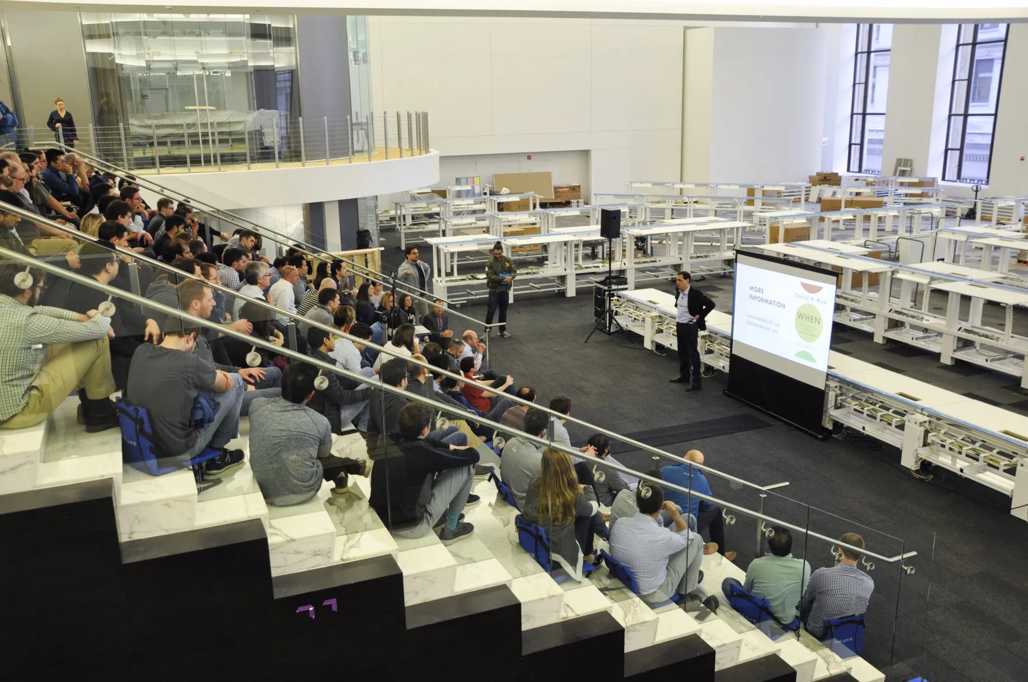 A speaker with a presentation stands in front of a large crowd of PEAK6 employees, all listening attentively.
Compliance Officer