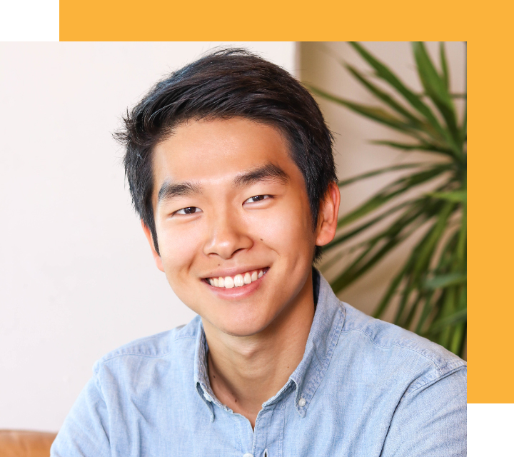 Headshot of Bolun Li, Founder & CEO of Zogo. Bolun is a young Asian person presenting as male. He's dressed in a casual blue oxford shirt, wears his hair short, and flashes a warm, open-mouthed smile.