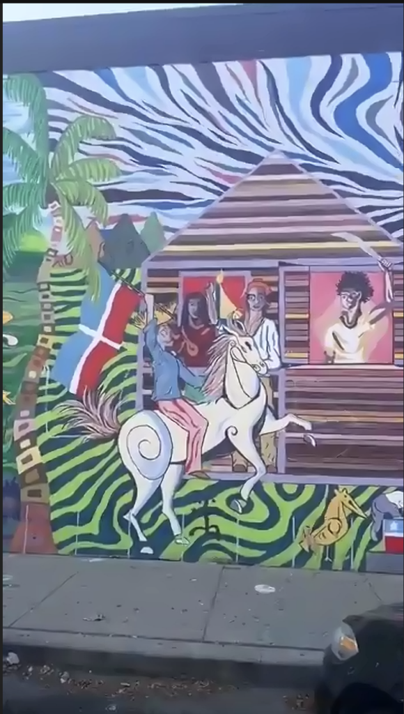 A mural of someone on a horse, waving to people in a house.